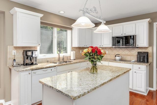 kitchen with dishwasher, sink, white cabinets, and decorative light fixtures