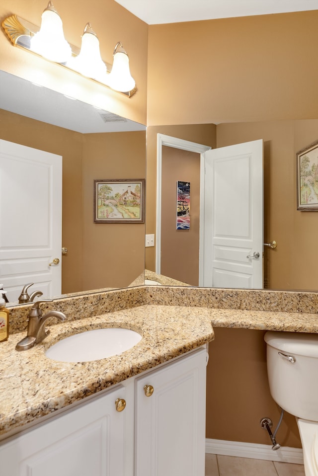 bathroom featuring tile patterned flooring, vanity, and toilet