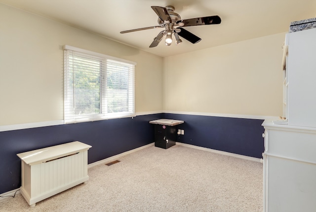 miscellaneous room featuring radiator, light colored carpet, and ceiling fan