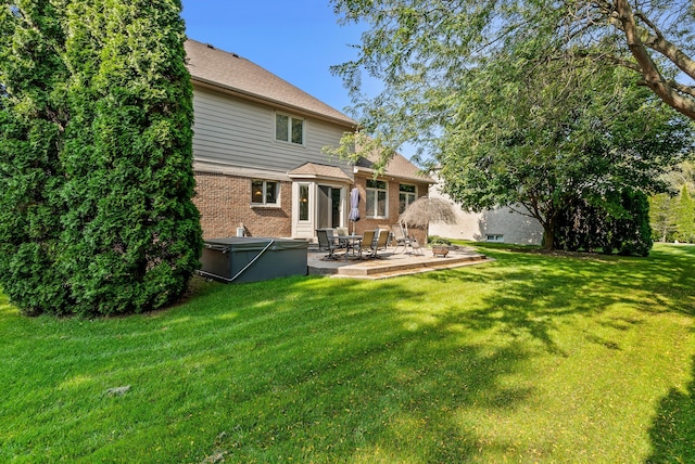 rear view of property with a lawn and a patio area