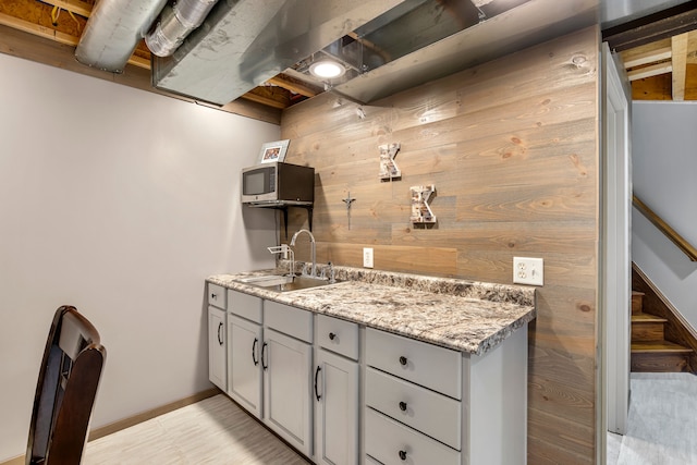22461 Milner St, Saint Clair Shores, MI 48081 - kitchen featuring light stone counters, a sink, gray cabinetry, stainless steel microwave, and baseboards