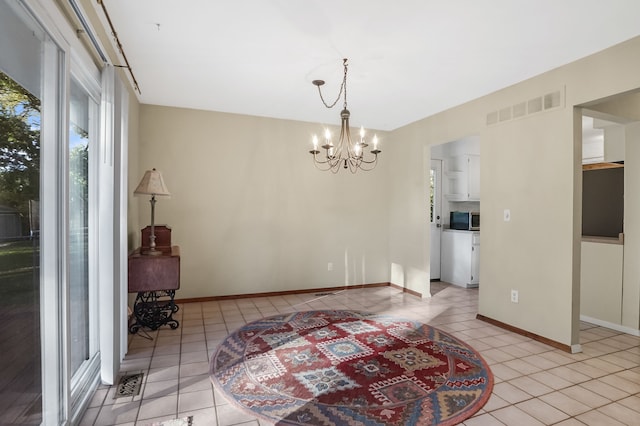 dining room featuring light tile patterned flooring and an inviting chandelier