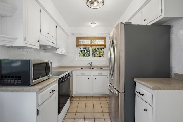 kitchen featuring white cabinetry, sink, light tile patterned floors, and appliances with stainless steel finishes