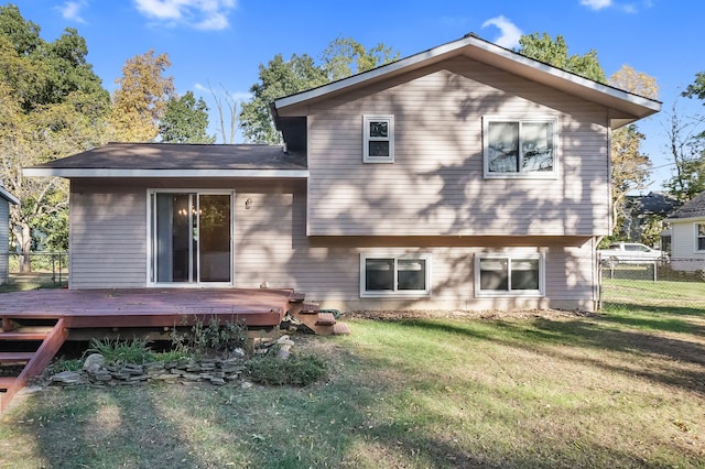 back of property featuring a lawn and a wooden deck