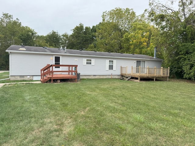 rear view of house featuring a lawn and a deck