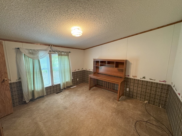 misc room with carpet, ornamental molding, a textured ceiling, and tile walls