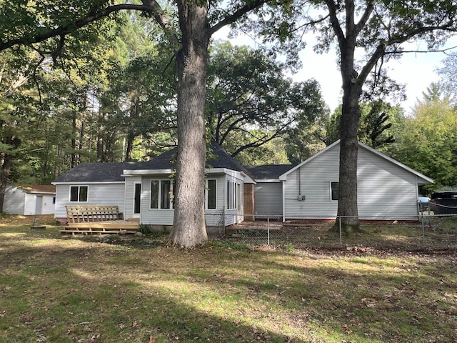 back of property featuring a wooden deck and a yard