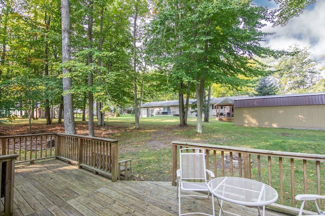 wooden deck with a lawn and an outdoor structure