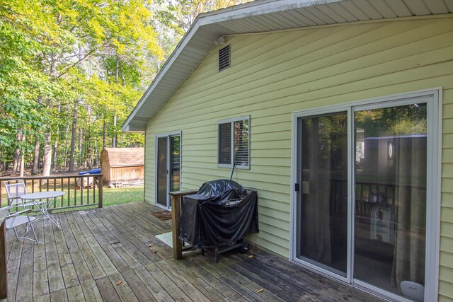 wooden deck featuring a grill