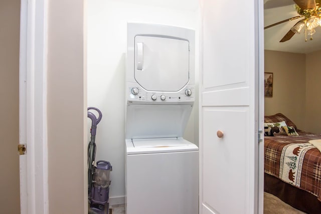 washroom featuring stacked washer / dryer and ceiling fan