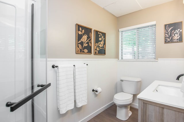 bathroom featuring hardwood / wood-style floors, vanity, toilet, and a shower