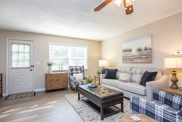 living room featuring wood-type flooring and ceiling fan