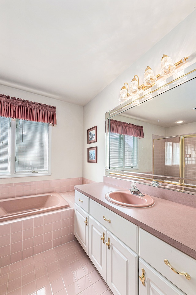 bathroom featuring vanity, tiled bath, tile patterned floors, and a wealth of natural light