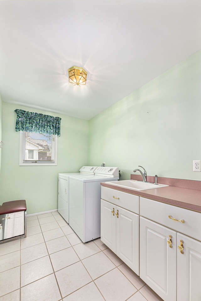 laundry area with cabinets, light tile patterned floors, washing machine and dryer, and sink