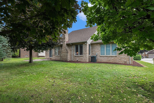 view of front facade with a front yard and cooling unit