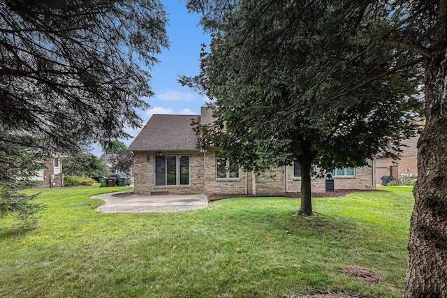 rear view of house with a patio and a lawn