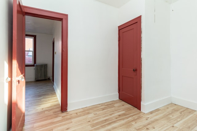 hall with radiator heating unit and light hardwood / wood-style flooring