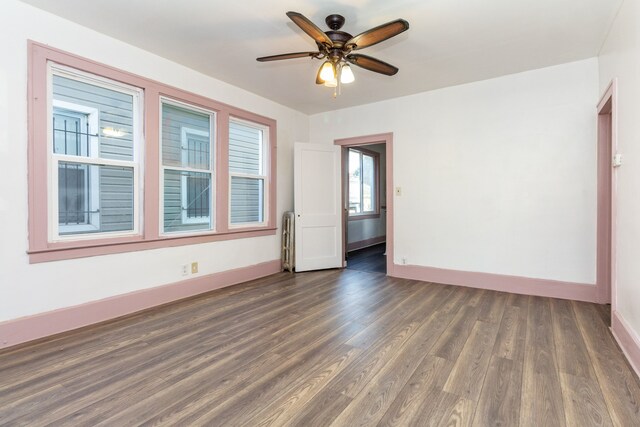 11434 Mcdougall St, Hamtramck, MI 48212 - unfurnished room featuring baseboards, dark wood-style floors, ceiling fan, and radiator heating unit