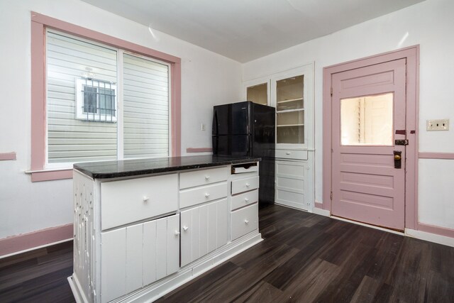 11434 Mcdougall St, Hamtramck, MI 48212 - kitchen with white cabinetry, dark wood-type flooring, glass insert cabinets, dark stone countertops, and baseboards