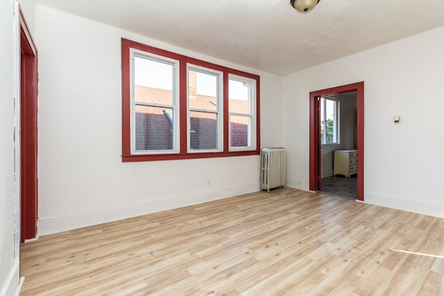 empty room featuring radiator and light hardwood / wood-style floors