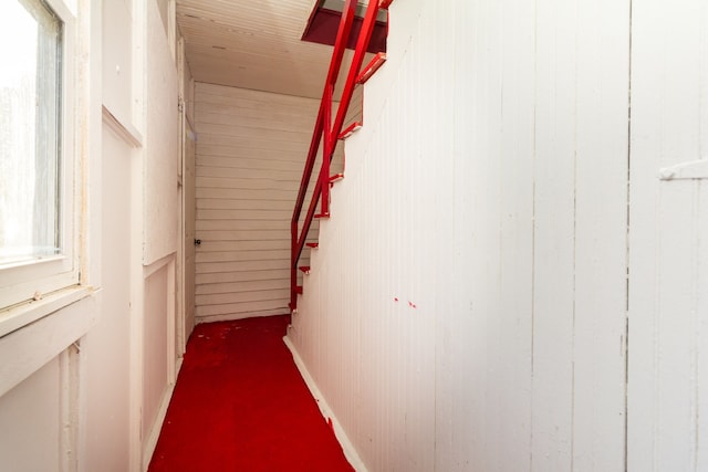 hall with carpet and wooden walls