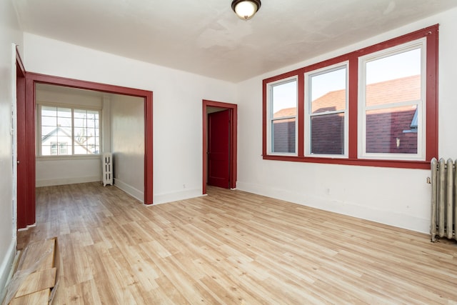 spare room with light wood-type flooring and radiator heating unit