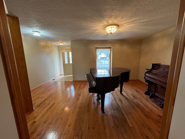 miscellaneous room featuring wood-type flooring and a textured ceiling