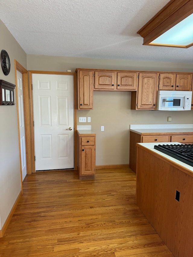 kitchen with light hardwood / wood-style floors and a textured ceiling