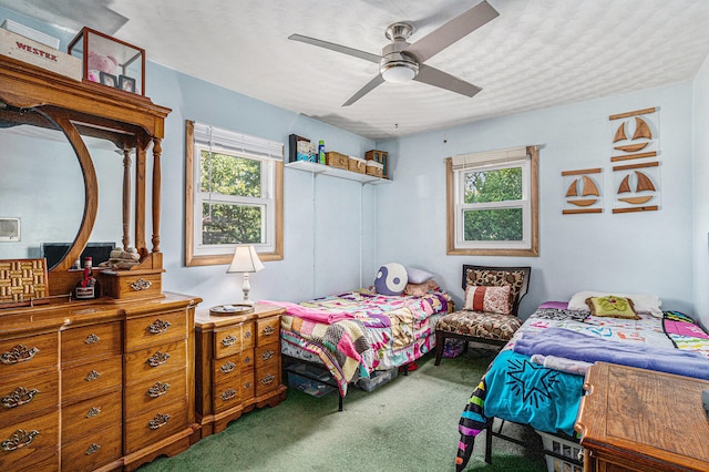 carpeted bedroom with ceiling fan and multiple windows