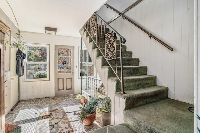 stairs featuring carpet and wood walls