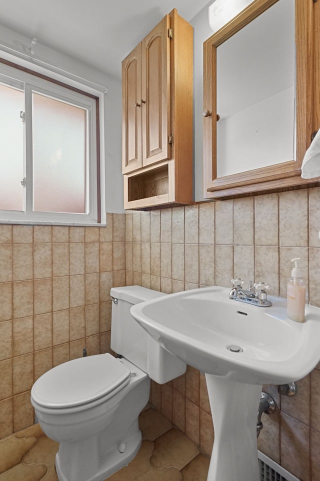 bathroom with tile walls and toilet