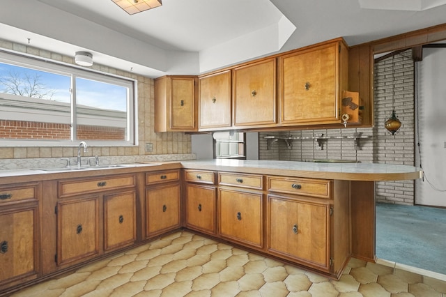 kitchen with light carpet, sink, backsplash, and kitchen peninsula