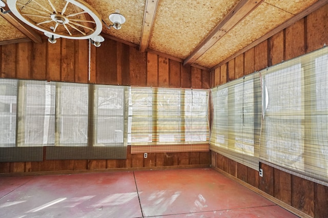 unfurnished sunroom featuring vaulted ceiling with beams