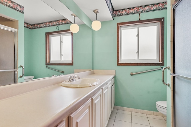 bathroom with tile patterned floors, toilet, a shower with shower door, and vanity