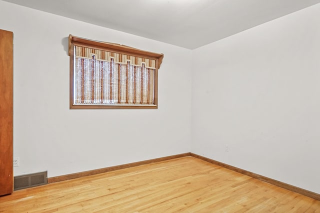 unfurnished room with hardwood / wood-style flooring