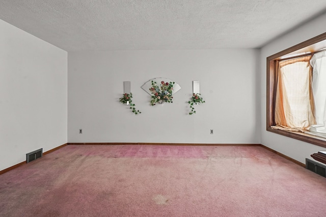 carpeted spare room with a textured ceiling