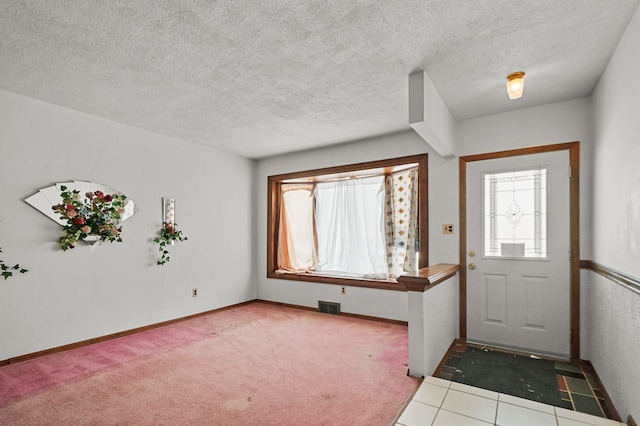 entryway featuring carpet and a textured ceiling