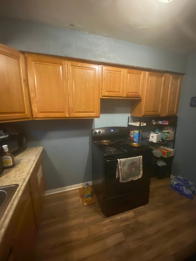 kitchen with dark hardwood / wood-style floors and black appliances