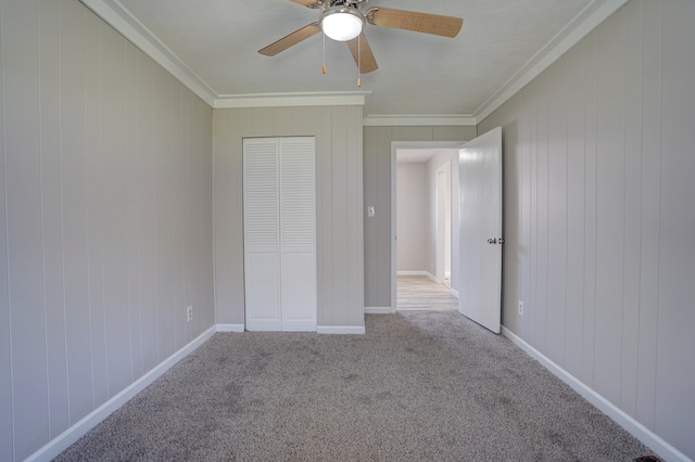 unfurnished bedroom featuring carpet flooring, baseboards, a ceiling fan, and ornamental molding