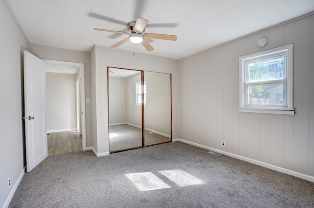 unfurnished bedroom featuring visible vents, a closet, carpet floors, baseboards, and ceiling fan