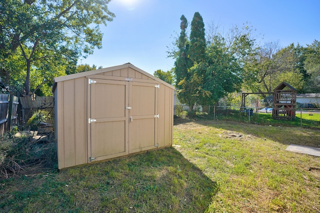 view of shed with a fenced backyard and a playground