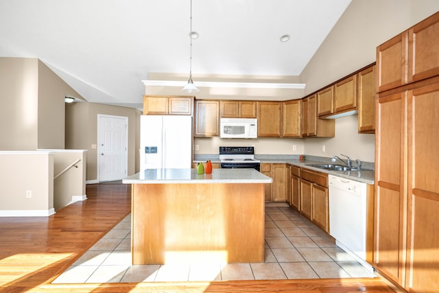 kitchen featuring sink, light hardwood / wood-style flooring, decorative light fixtures, white appliances, and a kitchen island