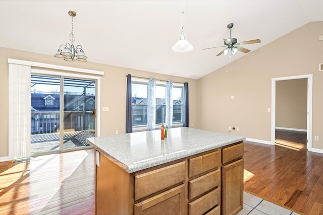 kitchen featuring decorative light fixtures, a center island, light hardwood / wood-style floors, and vaulted ceiling