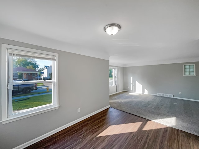 empty room featuring dark hardwood / wood-style floors and plenty of natural light