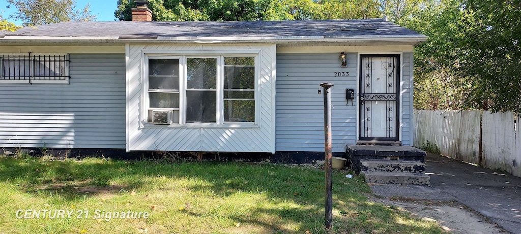 doorway to property with cooling unit and a yard