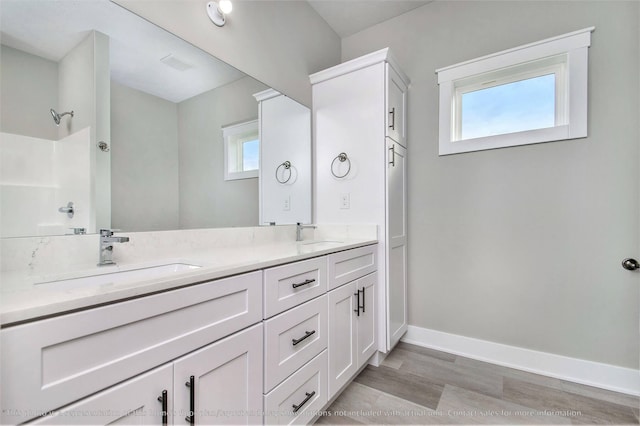 bathroom featuring walk in shower, vanity, a healthy amount of sunlight, and hardwood / wood-style flooring