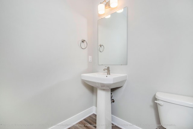 bathroom featuring wood-type flooring and toilet