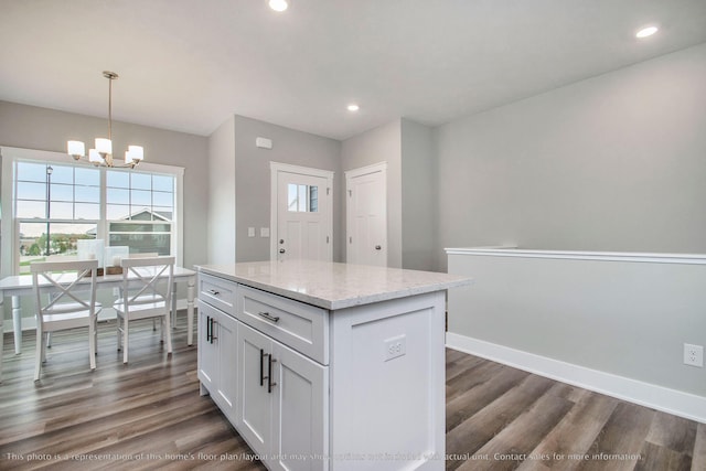 kitchen with hanging light fixtures, a kitchen island, dark hardwood / wood-style flooring, white cabinetry, and a chandelier