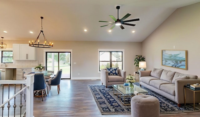 living room featuring wood-type flooring, ceiling fan with notable chandelier, and high vaulted ceiling