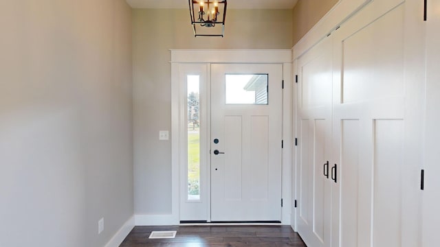 entrance foyer with dark hardwood / wood-style floors and a chandelier